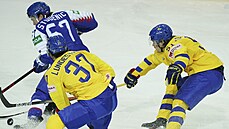 védská dvojice Isac Lundeström a Filip Hallander napadá slovenského hokejistu...
