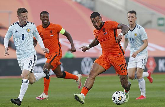 Nizozemský fotbalista Memphis Depay prochází skotskou obranou.
