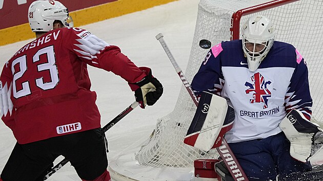 Švýcarský útočník Philipp Kurašev zkouší pozornost britského gólmana Bena Bownse.