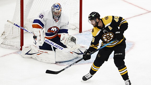David Krejčí z Bostonu tečuje puk před Semjonem Varlamovem z NY Islanders.