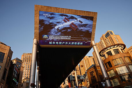 Obí obrazovka ukazuje obrázek kosmické lodi s posádkou Shenzhou-12, která...