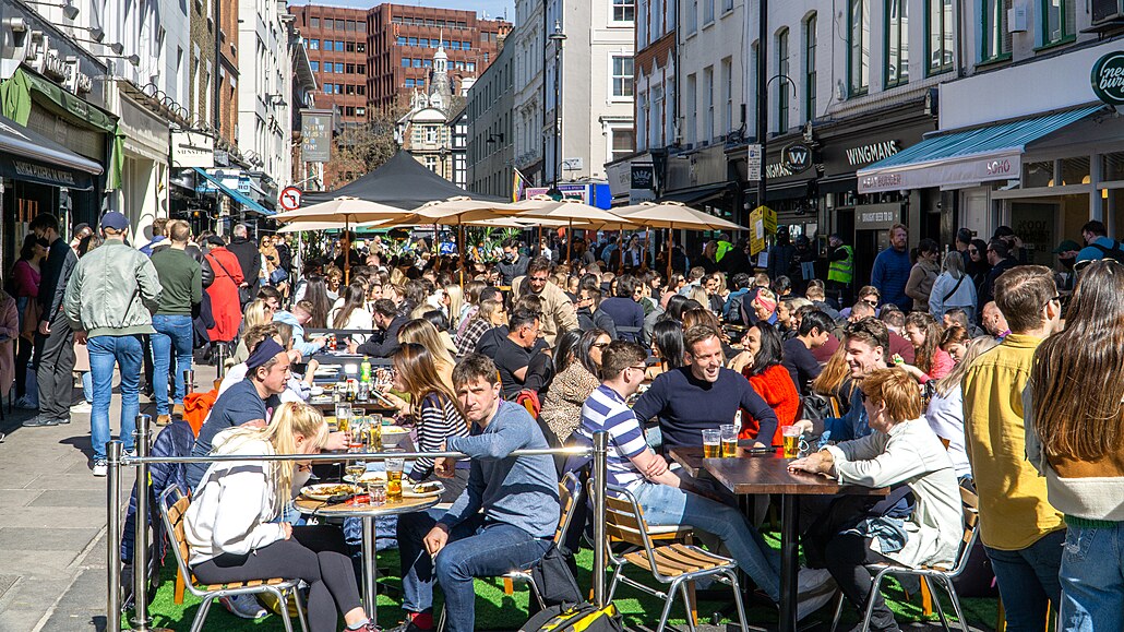 Venkovní pití a stolování mimo hospody na ulici Old Compton Street, Soho v...