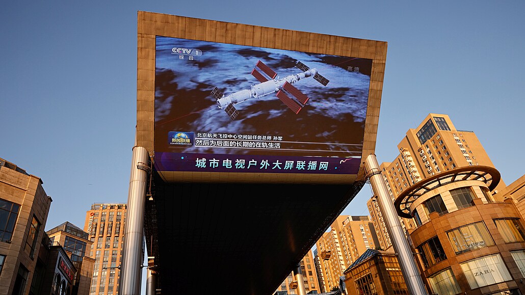 Obí obrazovka ukazuje obrázek kosmické lodi s posádkou Shenzhou-12, která...