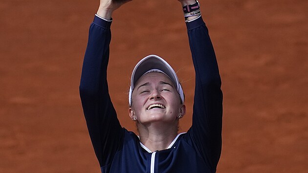 Barbora Krejčíková zvedá nad hlavu trofej pro vítězku dvouhry na French Open.