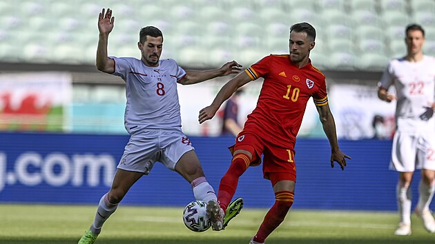 Remo Freuler (vcarsko) a Aaron Ramsey (Wales) v souboji o m.