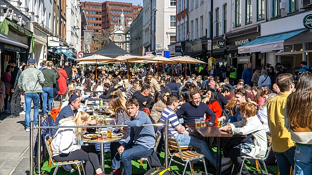 Venkovní pití a stolování mimo hospody na ulici Old Compton Street, Soho v centru Londýna. (18. dubna 2021)