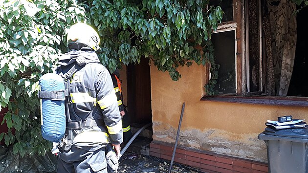 Ze silně zakouřeného rodinného domu vynesli hasiči seniorku. Příjezd k požáru jim 17. června 2021 komplikovala zaparkovaná auta.