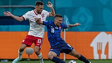 Lukáš Haraslín ze Slovenska padá po souboji s polským obráncem Maciejem Rybusem.