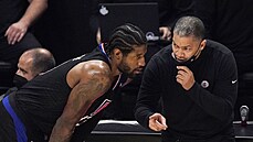 Trenér Los Angeles Clippers Tyronn Lue pedává pokyny, Paul George naslouchá.