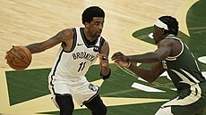 Kyrie Irving (vlevo) z Brooklynu se tlaí kolem Jrue Holidaye z Milwaukee.