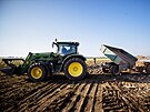 Traktor s valníkem odbáí trosky na provizorní skládku na pole mezi obcí Hruky...