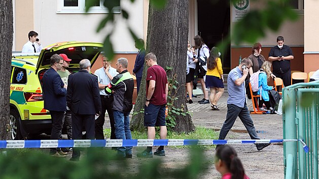 Záchranáři ošetřují lidi s kolapsy na sokolovské střední škole. (25. června 2021)