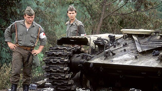 BOJE
Jugoslávští vojáci prohlížejí trosky ohořelého tanku po bojích na Slovinsko - Chorvatské hranici.