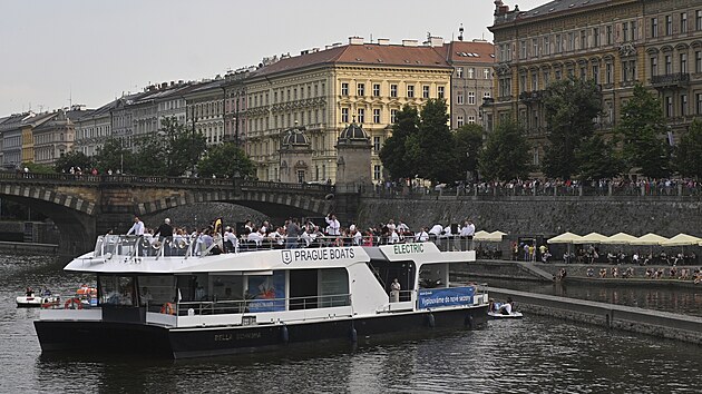 Lid sleduj open air koncert orchestr Nrodnho divadla a Sttn opery s nzvem Nrodn na vod 19. ervna 2021 podl Vltavy v centru Prahy.