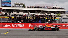 Max Verstappen z Red Bullu projídí cílem kolem svých týmových koleg.