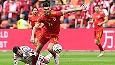 Kieffer Moore z Walesu uniká leícímu dánskému záloníkovi Pierru-Emilu...