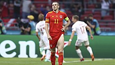 Velský kapitán Gareth Bale smutní, zatímco dántí fotbalisté slaví druhý gól.