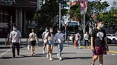 Lidé se v rouškách procházejí po ulici v Singapuru. (22. května 2021)