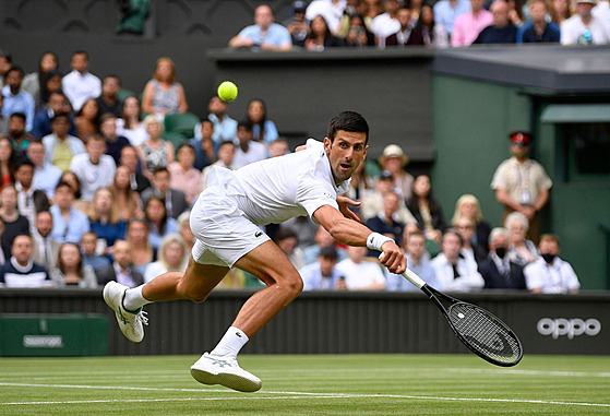 Srbský tenista Novak Djokovič se natahuje po balonku v semifinále Wimbledonu.