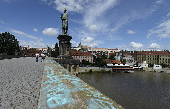 Neznámý vandal 9. ervence 2021 posprejoval ást Karlova mostu v Praze. Modré...