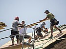 Dobrovolníci staví novou stechu rodinného domku v Mikulicích. Do takové práce...