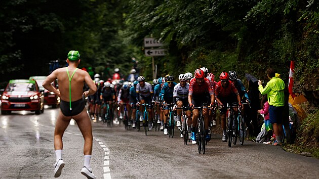 Cyklist jedou po trati devt etapy Tour de France, v duhov dresu se vepedu pohybuje i Julian Alaphilippe.