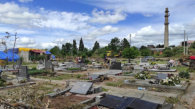 Na mikulčickém hřbitově uklízejí dobrovolníci větve a střepy. Obcí se 24. června 2021 prohnalo tornádo.