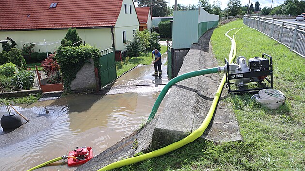 Hasii oderpvaj vodu ze zatopench objekt 9. ervence 2021 ve Starm Plzenci na Plzesku, kde se po silnch detch vylila z beh eka slava.