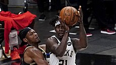 Jrue Holiday z Milwaukee u míe, brání ho Cam Reddish z Atlanty.