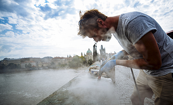 Restaurátor Jakub Tluho od ranních hodin pracuje na Karlov most na...