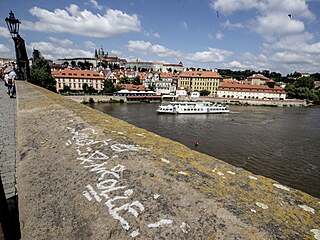 Neznámý vandal posprejoval část Karlova mostu v Praze. Podle policie je nápis u...