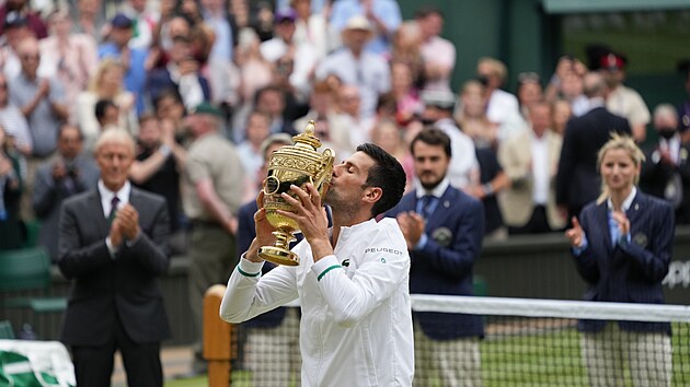 Vtzn polibek Novaka Djokovie s trofej pro ampiona Wimbledonu.