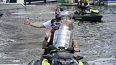 Nikita Kuerov (v bílém) a Alex Killorn vezou na skútru Stanley Cup.