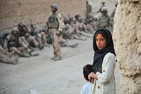Afghánská dívka ped skupinou voják lemují ulici ve vesnici Argan v provincii...