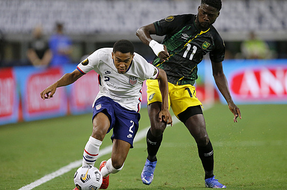 Americký fotbalista Reggie Cannon (vlevo) v souboji s Darylem Dikem z Jamajky.