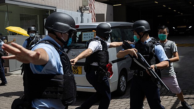 Ozbrojen hongkongt policist str dodvku s Tong Ying Kitem, kter je jako prvn lovk souzen na zklad kontroverznho bezpenostnho zkona schvlenho Pekingem pes mstn a mezinrodn odpor. (6. ervence 2020)