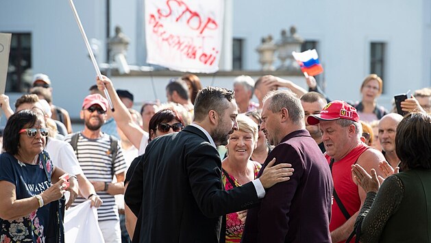 Dav odpůrců očkování blokuje vchod do slovenského parlamentu. Promluvili k nim opoziční politici Marian Kotleba (ve fialovém saku) a Ľuboš Blaha. (uprostřed, 23. července 2021)