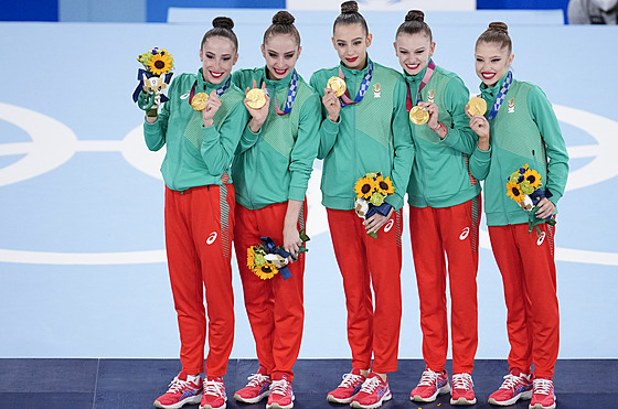 Bulharské moderní gymnastky ukazují zlaté medaile.