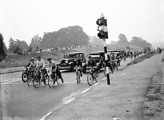 Kolona aut a cyklist eká na zelenou. (1935)