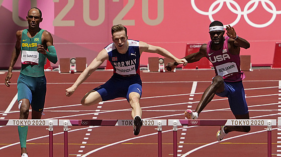 Norský běžec Karsten Warholm (uprostřed) se řítí vstříc olympijskému zlatu a...