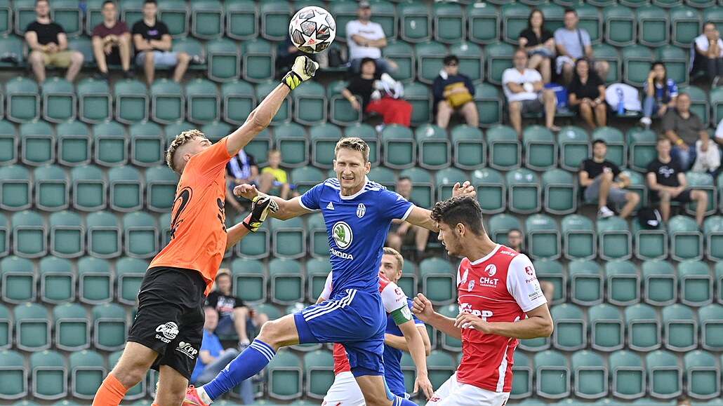 Pardubický branká� Jakub Markovi� vyrá�í centr p�ed nabíhajícím boleslavským...