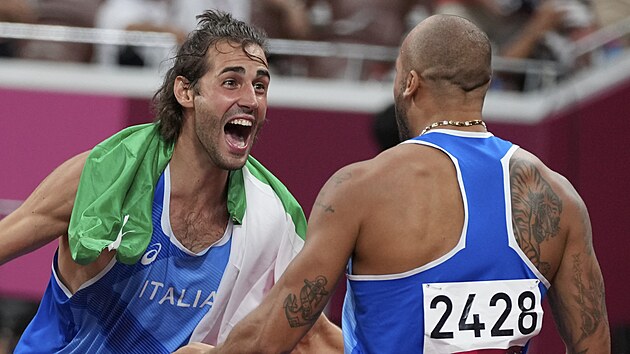 Gianmarco Tamberi objímá vítěze sprintu na 100 metrů Lamonta Jacobse. (1. srpna 2021)