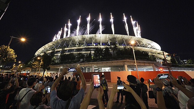 Lidé okolo olympijského stadionu sledují ohňostroj při závěrečném ceremoniálu letních olympijských her 2020. Neděle 8. srpna 2021, Tokio, Japonsko