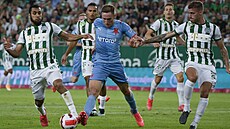 Slávistický útoník Jan Kuchta se probíjí obranou Ferencvárose v úvodním duelu...
