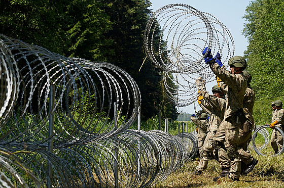 Litevští vojáci instalují žiletkový drát na hranici s Běloruskem. (9. července...