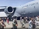 Stovky lidí se snaí dostat do amerického nákladního letadla C-17 s cílem...