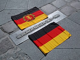 Vlajka NDR a Německa v Bernauer Strasse na místě, kde stála Berlínská zeď.