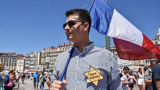 Muž má na protestu proti průkazu zdraví v Marseille na hrudníku připevněnou žlutou Davidovu hvězdu. (17. července 2021)