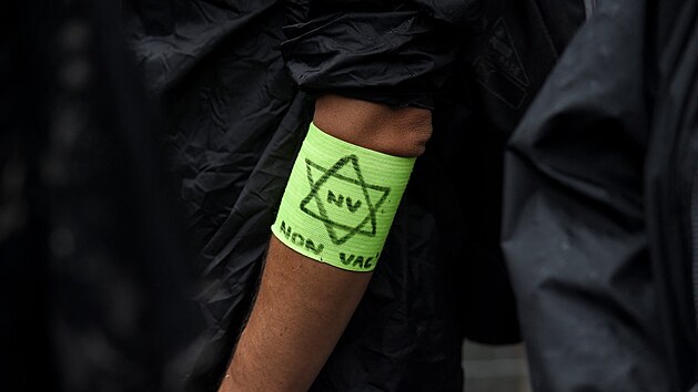 Muž má na protestu proti průkazu zdraví v Nantes na ruce připevněnou žlutou Davidovu hvězdu. (24. července 2021)
