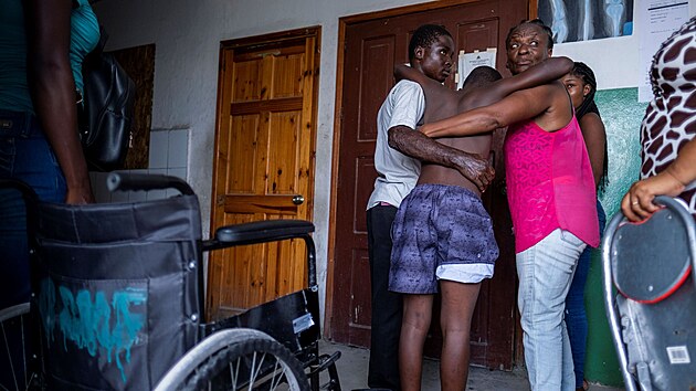 Příbuzní vedou do nemocnice ve městě Les Cayes zraněného muže. (16. srpna 2021)